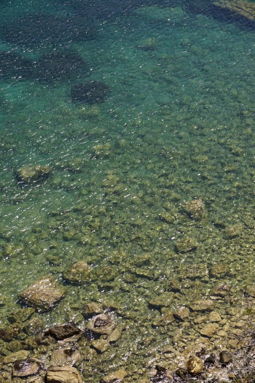 Free Shallow clear sea water over a rocky beach captured from above. Stock Photo