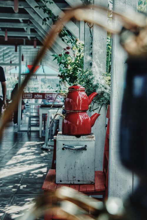 Free Artistic shot of vintage red kettles in a charming outdoor cafe in Aladağ, Türkiye. Stock Photo