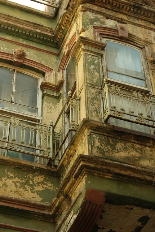 Free Close-up of an abandoned building facade with antique railings and weathered windows. Stock Photo