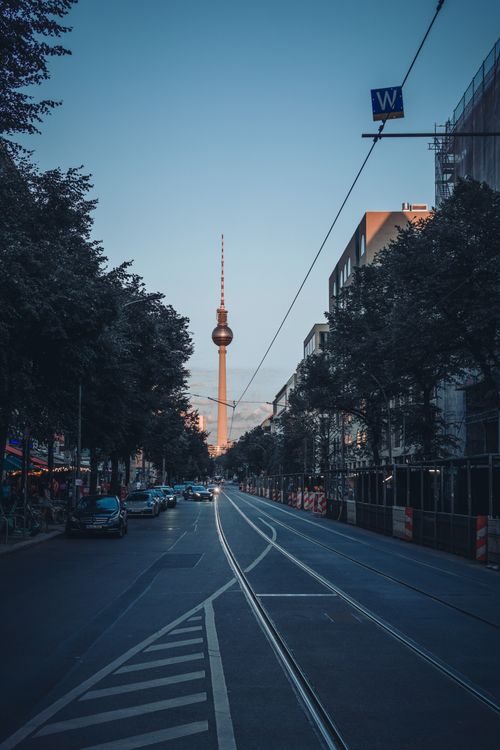 Free Beautiful view of the Berlin TV Tower from a city street at sunset, capturing urban symmetry. Stock Photo