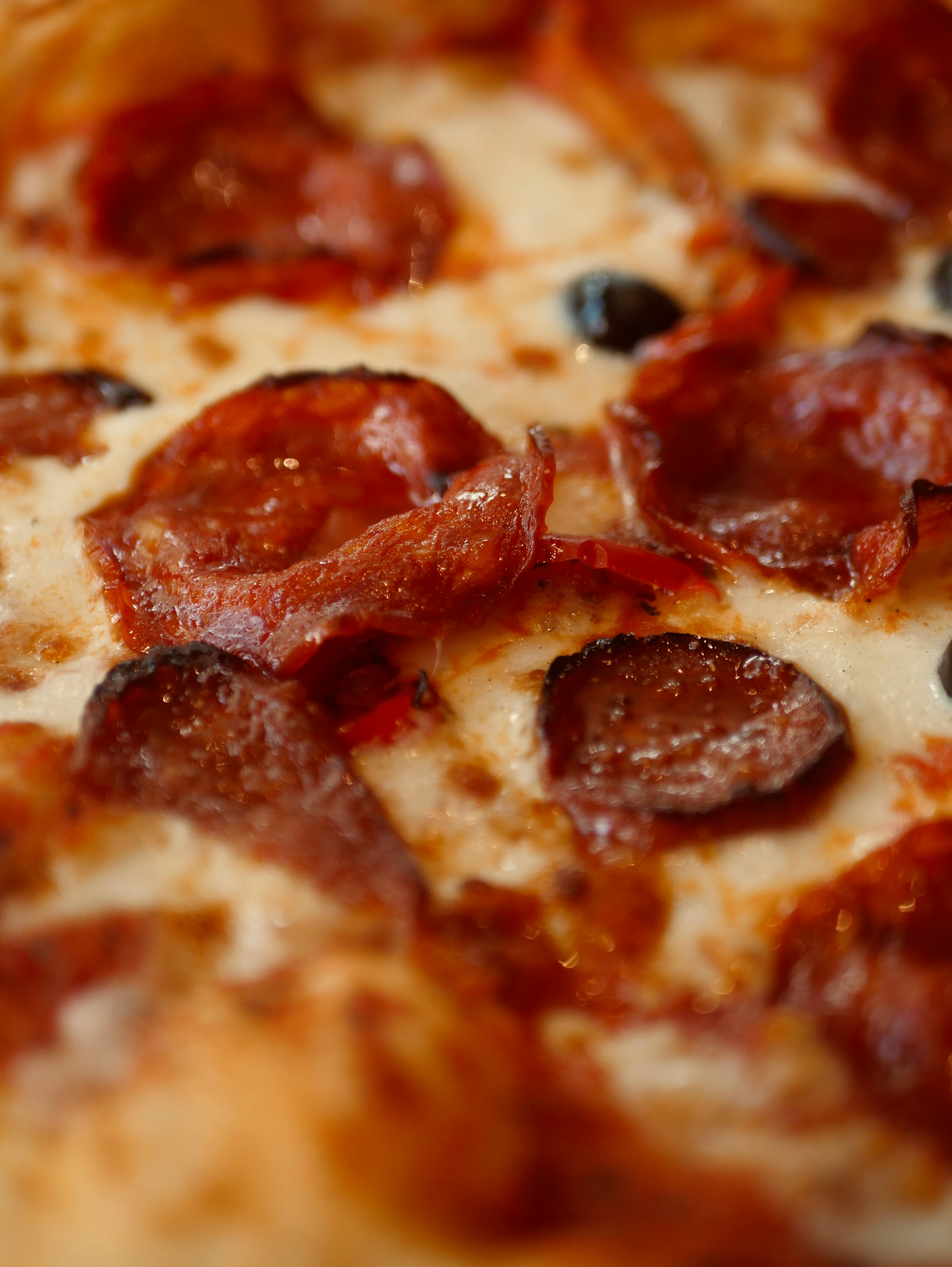 Mouthwatering close-up of a pepperoni pizza slice with melted cheese and crispy crust.