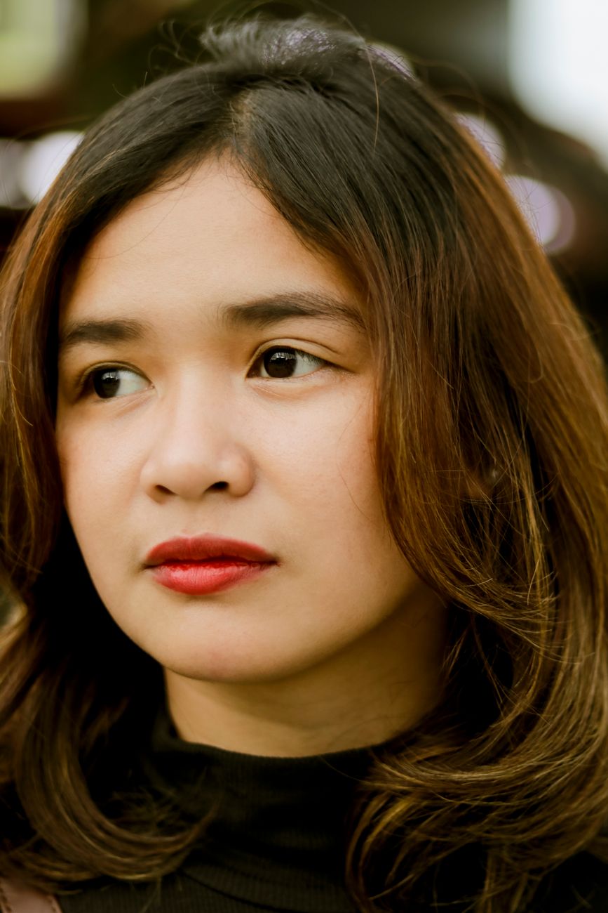Close-up portrait of a woman with red lipstick, captured indoors.
