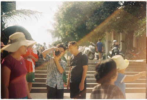 Men with Camera on Busy Street in Tropical Landscape