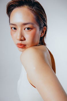 Close-up portrait of an East Asian woman looking confidently at the camera against a white background.