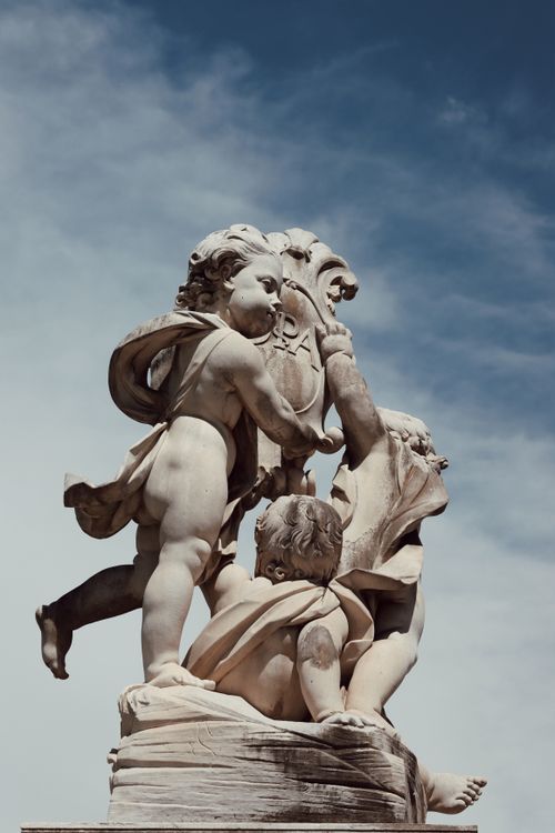 Free Elegant marble sculpture of cherubs in Pisa, Italy with a clear blue sky. Stock Photo