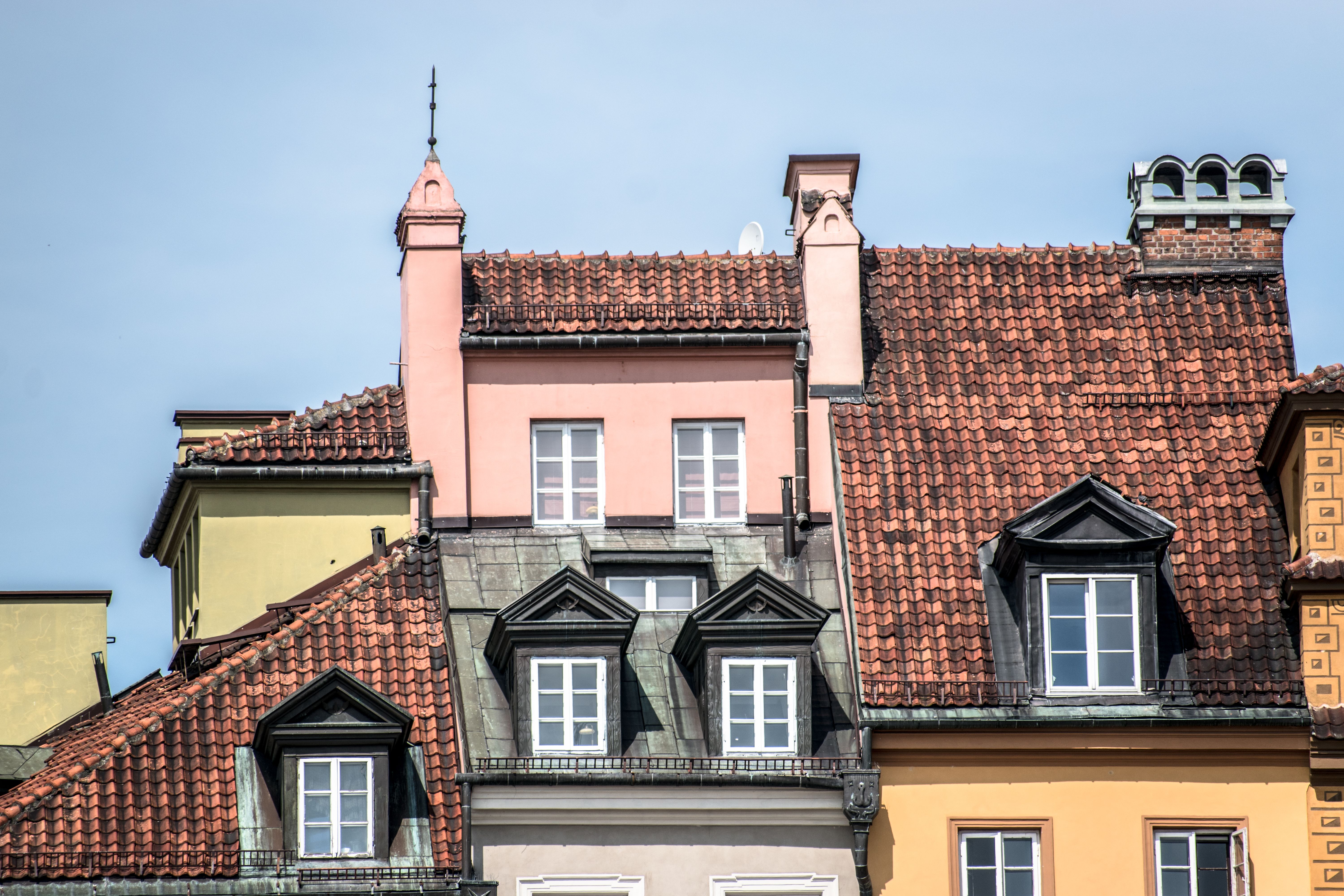 Close-up of colorful European townhouses with unique rooftops and windows.