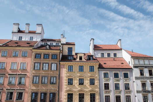 Charming street view of colorful European townhouses with classic architecture under a clear sky.