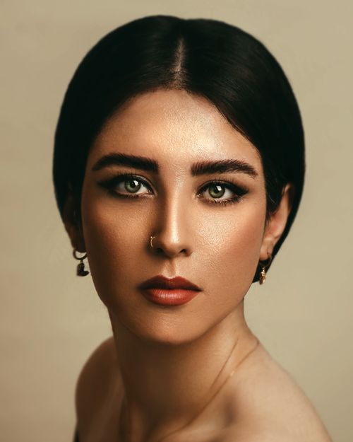 Free Stunning studio portrait of a woman with earrings and black hair, showcasing elegance and beauty. Stock Photo