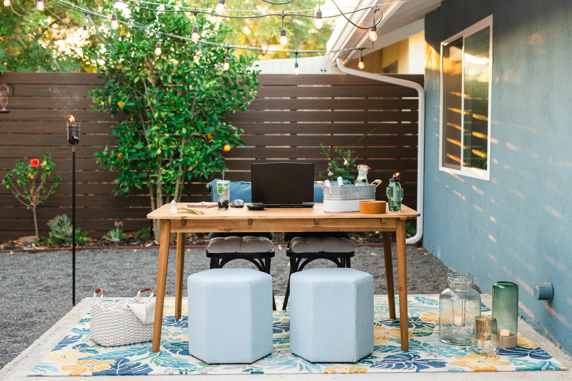 A patio with a table and chairs and a blue rug