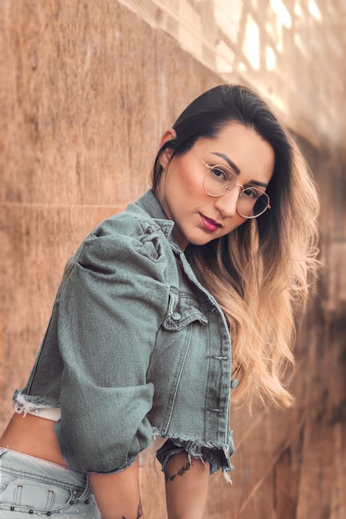 Sexy Woman in Glasses Posing near Wall