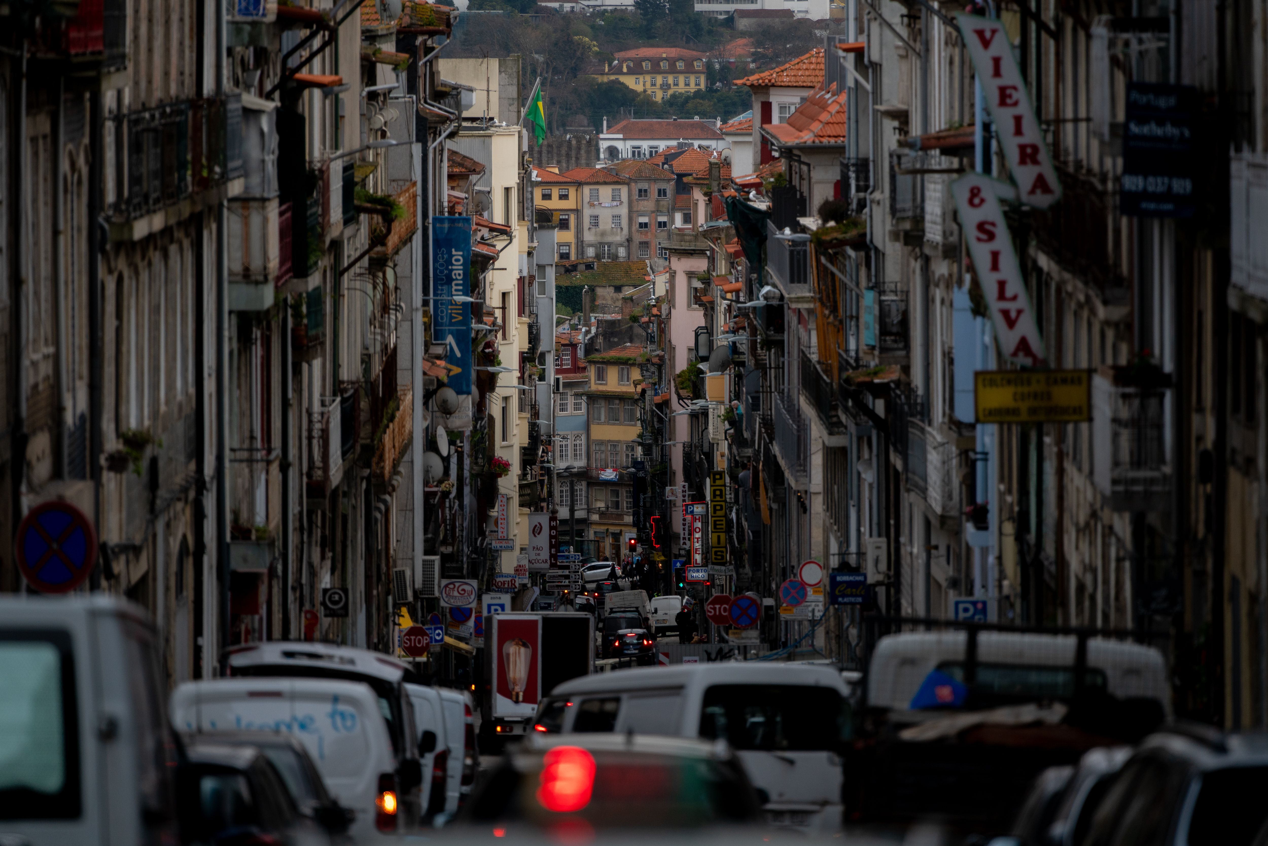 A bustling street scene in Porto, Portugal, showcasing urban life and architecture.