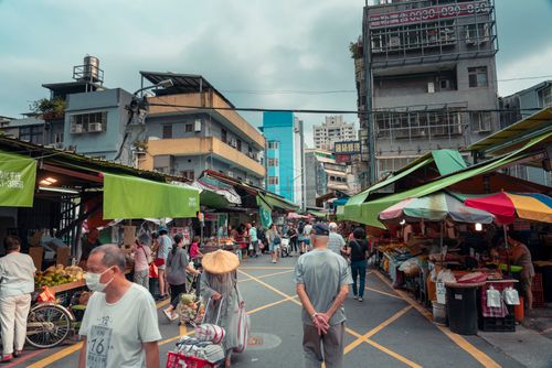 Free Daily life in a busy outdoor market street with people shopping and interacting. Stock Photo