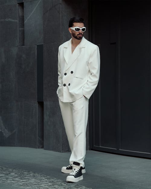 Model Posing in White Suit and Sunglasses