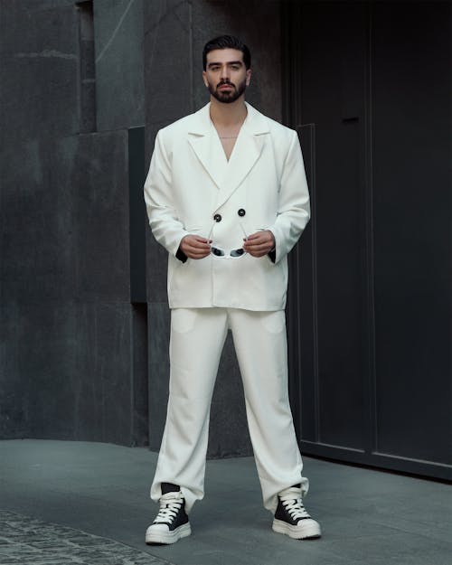 Model Posing in White Suit and Sneakers