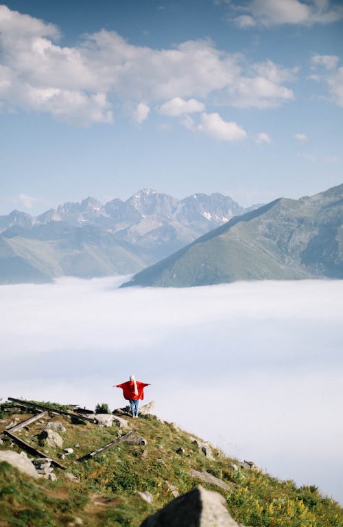 Hiker High in Mountains over Valley Covered with Fog