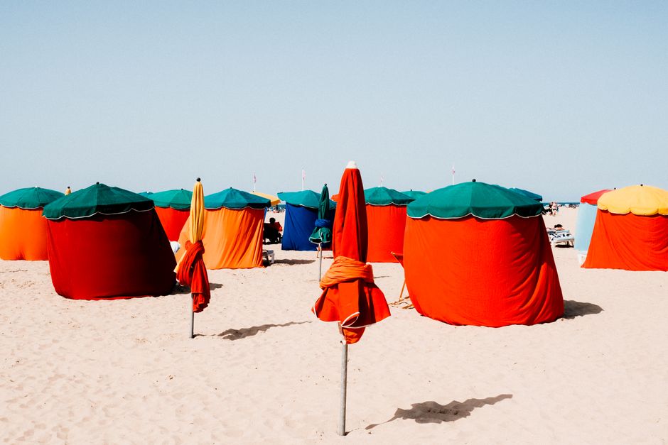 Colorful tents and sunshades on a sunny beach creating a vibrant, inviting summer scene.