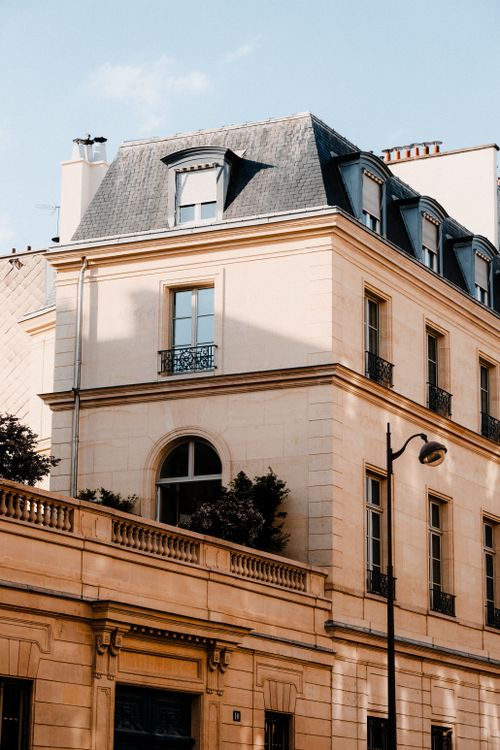 Free A classic Parisian building exterior with streetlight captured on a sunny day. Stock Photo
