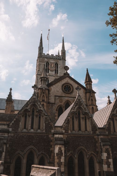 Free Southwark Cathedral's gothic architecture shines against a bright London sky, capturing its historical essence. Stock Photo
