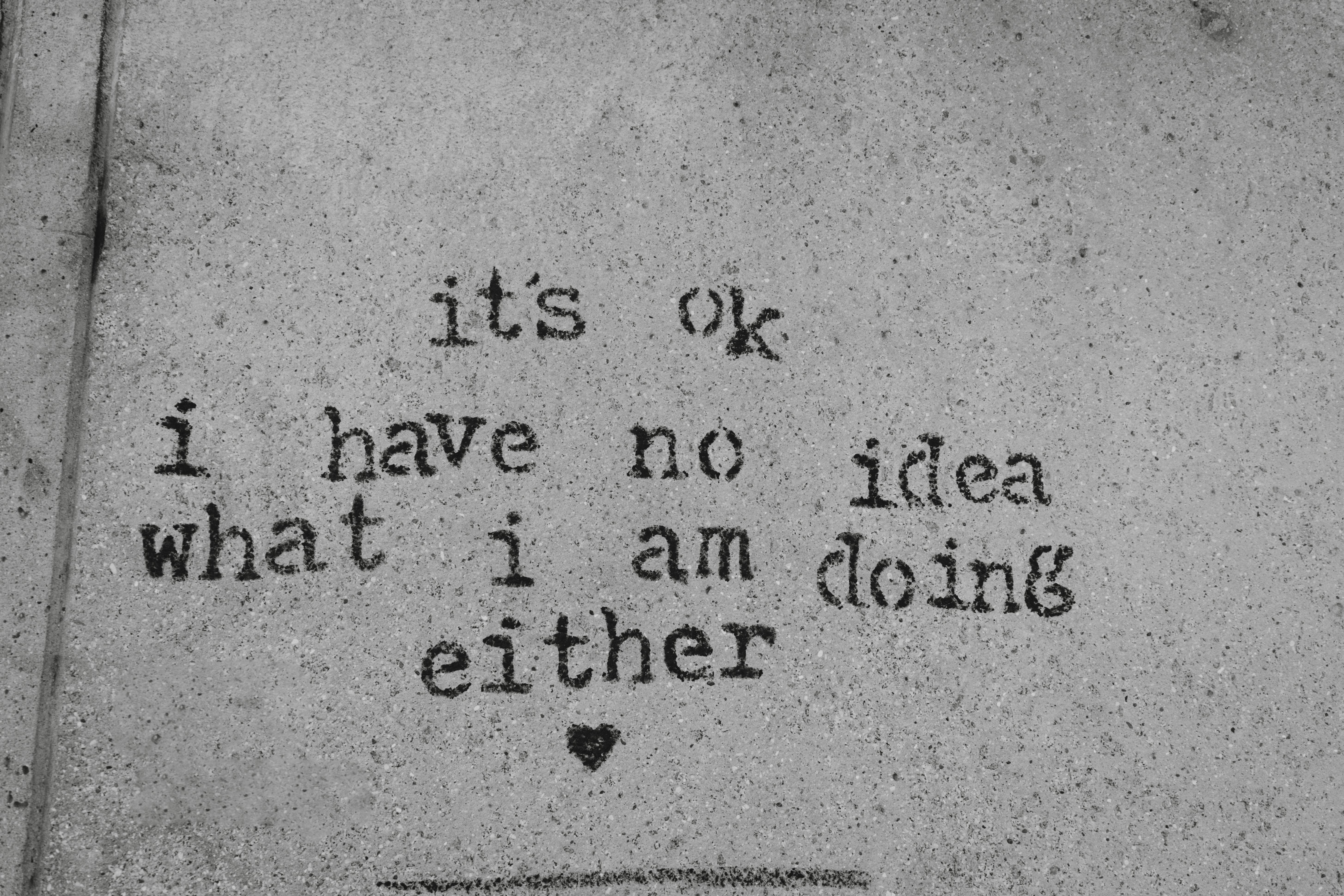 Black and white graffiti on a wall in London with a humorous quote.