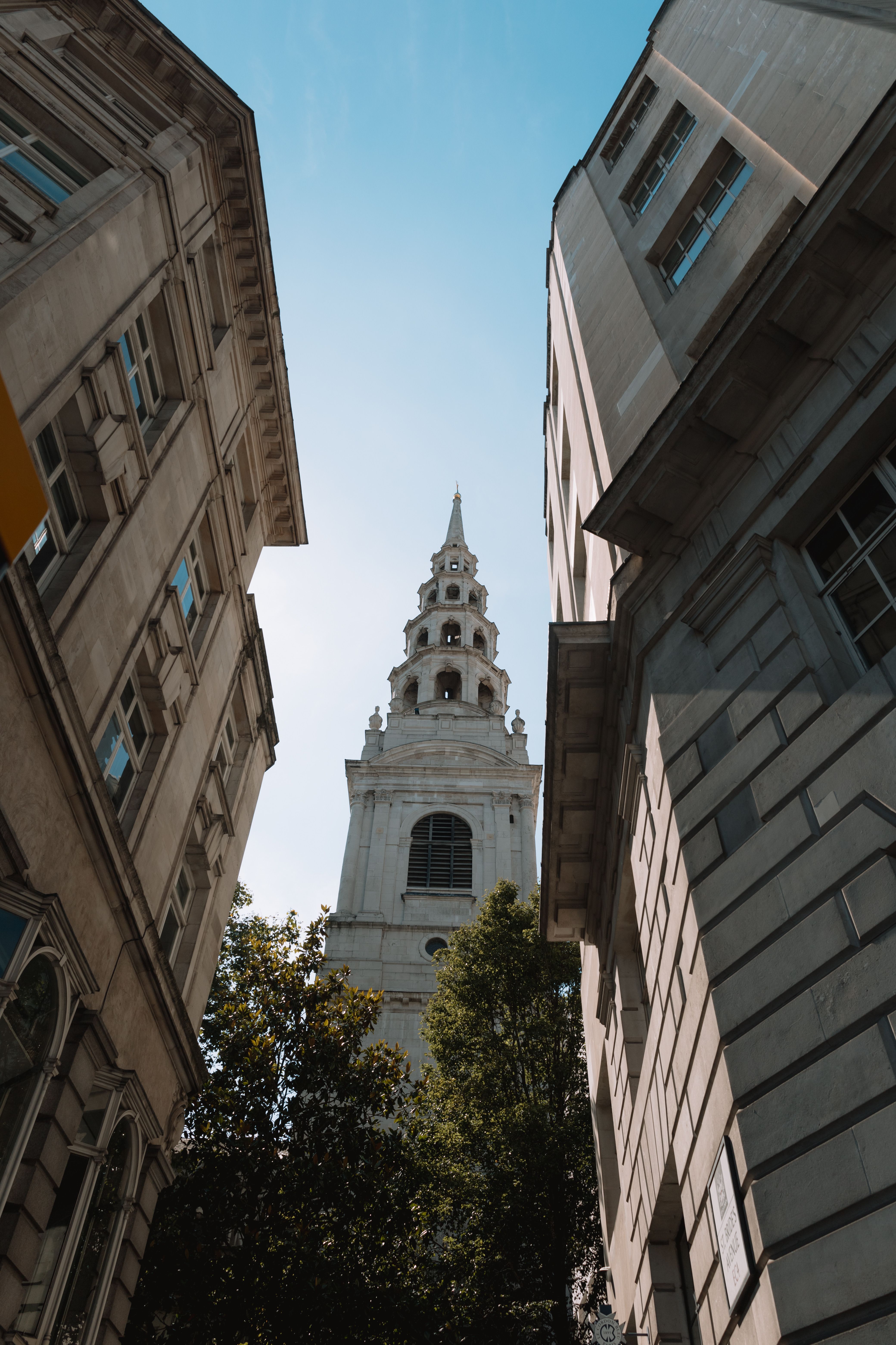 Low Angle Shot of Building Facades and a Church Tower · Free Stock Photo
