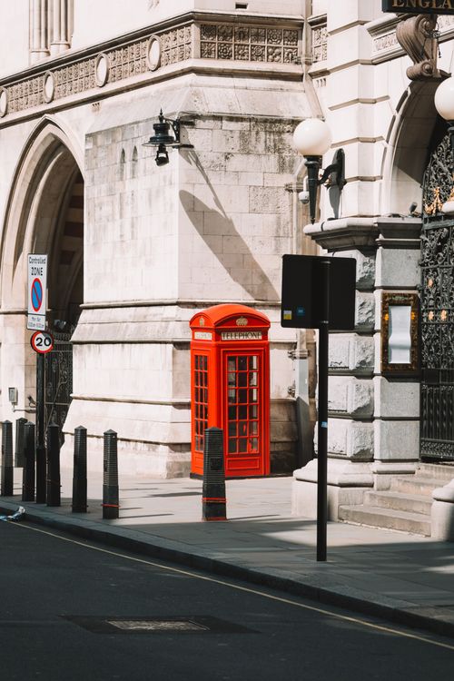 Free Classic red telephone box on a London street, capturing urban architecture. Stock Photo