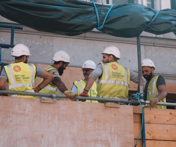 Lavoratori in cantiere con gilet ad alta visibilità ed elmetto
