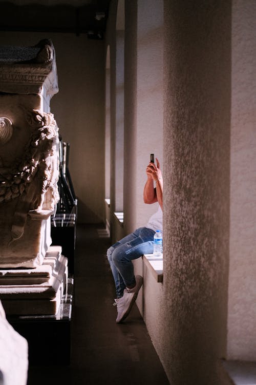Photo of a Woman Photographing an Architectural Detail in a Museum