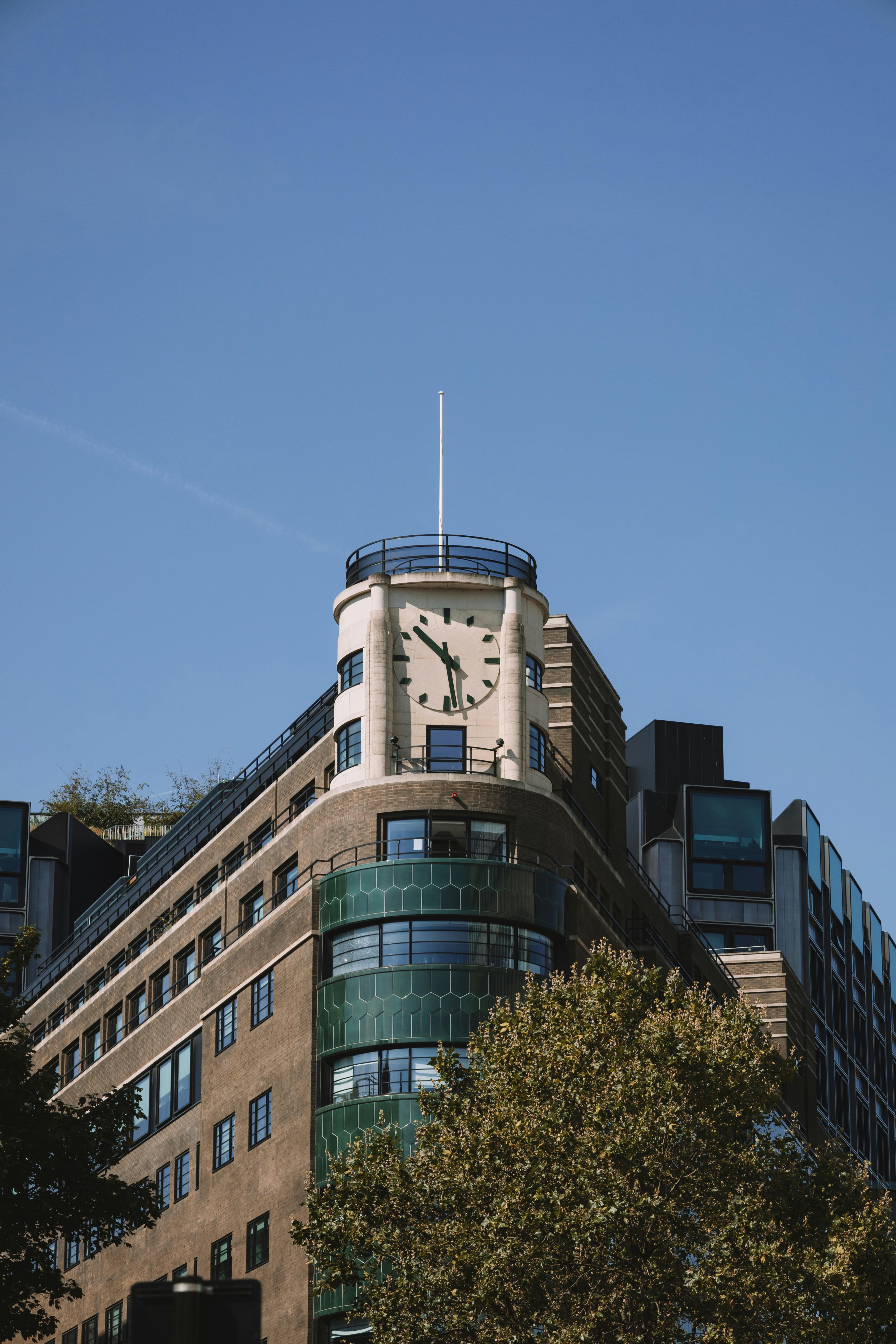 A modern Art Deco building with a prominent clock tower under a clear blue sky.