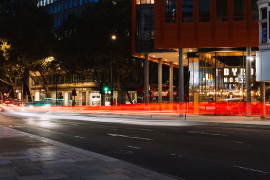 Dynamic urban night scene featuring vibrant light trails on busy city streets.