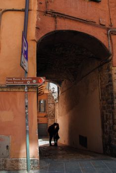 A couple shares a romantic moment under a historic archway in Perugia, Italy.