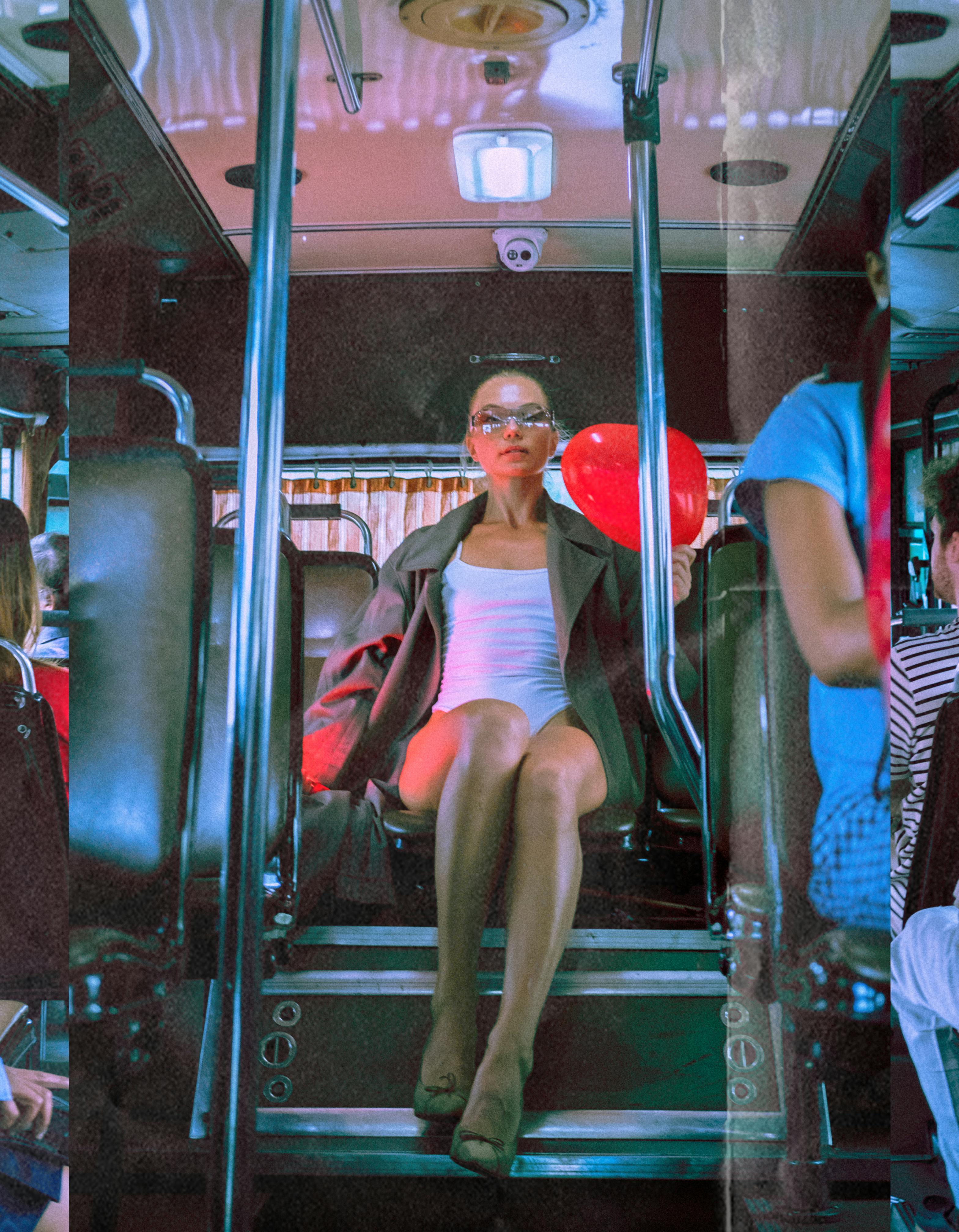 woman sitting in a bus holding a heart shaped balloon