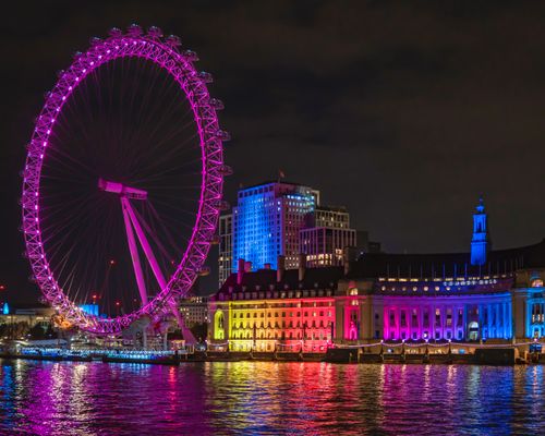 Free Stunning nighttime view of the illuminated London Eye reflecting on the River Thames. Stock Photo