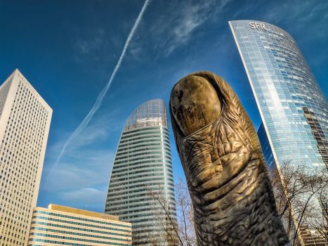 Iconic César's Thumb sculpture with skyscrapers in La Défense, Paris.