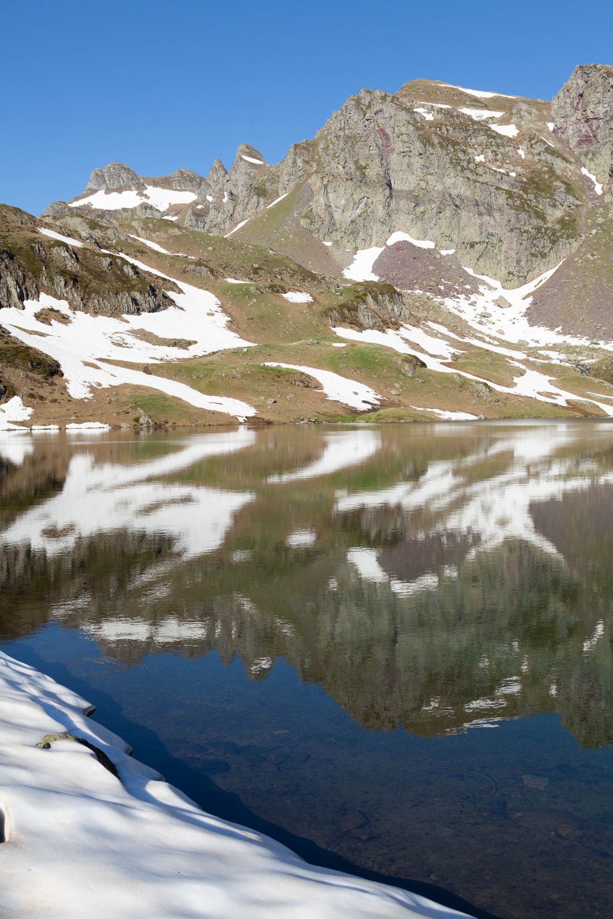 A deep-blue glacial lake reflecting the Pyrenean peaks
