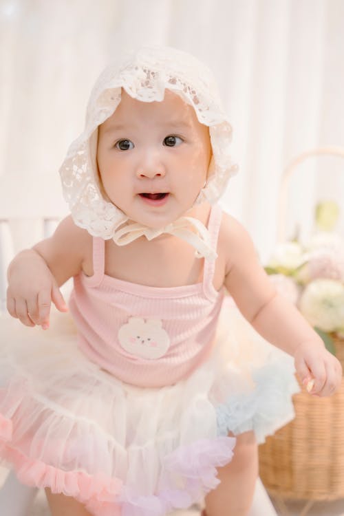 Baby in White Lace Bonnet Hat and Pink Dress