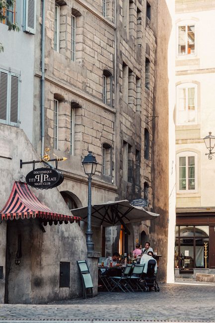 Outdoor café seating in a picturesque old town street in Geneva, Switzerland.