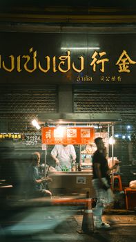Vibrant nighttime street food scene in a bustling urban Chinatown.