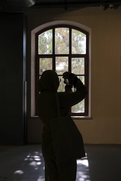 Photographer Taking Photo of Window in Building