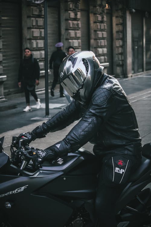Biker with Helmet on Black Motorcycle on Street