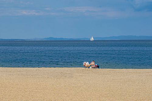 Free A serene beach scene in Roquetas de Mar with people relaxing under the sun. Stock Photo