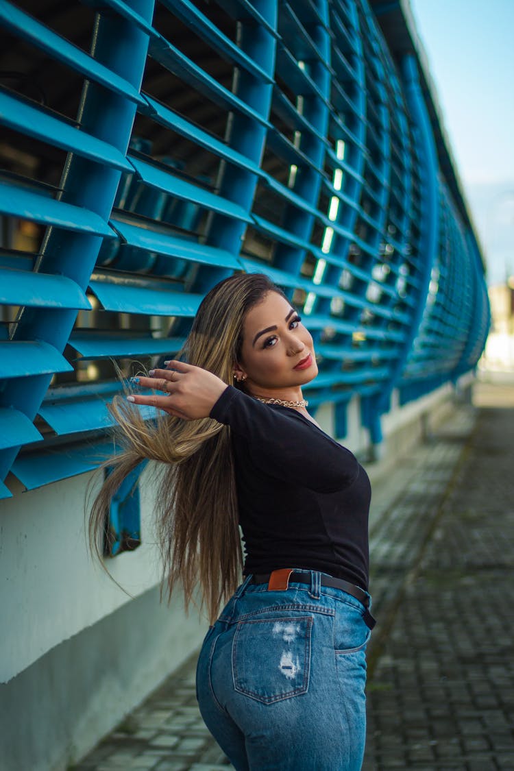 Blonde Woman Standing And Posing By Wall