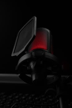 Vertical close-up of a glowing red microphone with pop filter against a dark backdrop.