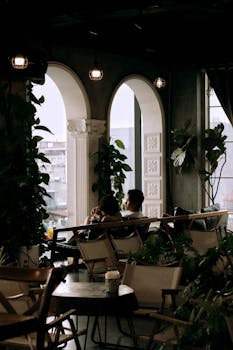 Charming indoor cafe setting with elegant arches and lush greenery.