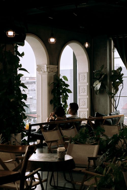 Free Charming indoor cafe setting with elegant arches and lush greenery. Stock Photo
