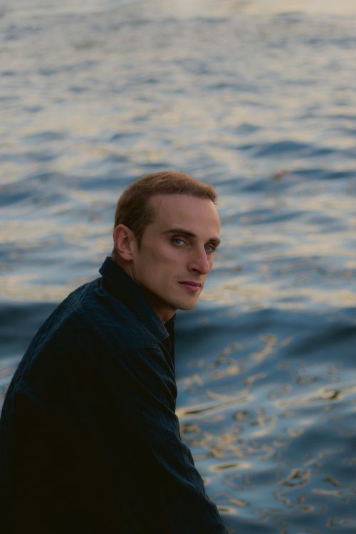 Free Portrait of a man by the sea with a contemplative expression, capturing serenity. Stock Photo