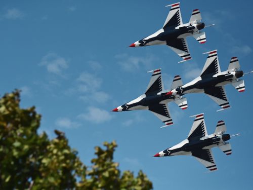 Free Aerial view of military jets flying in formation against a clear blue sky, showcasing precision. Stock Photo