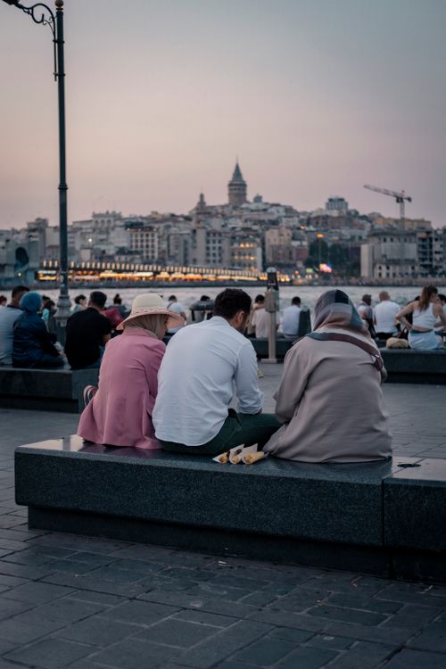 Free Evening view of Galata Tower with locals and tourists by the Bosphorus in Istanbul. Stock Photo