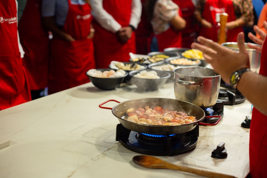 Participants learning hands-on cooking skills in a live class setting