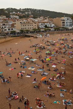 A vibrant beach scene with umbrellas and people enjoying summer on the sandy shore.