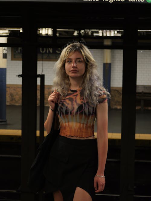 A woman standing in front of a subway station